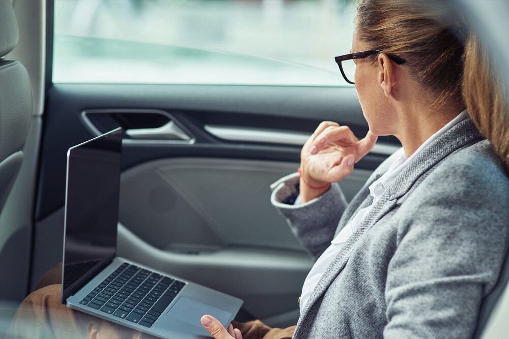 A Woman Is Sitting In The Back Seat Of A Car — Kingscliff Tweed Coast Taxis Pty Ltd In Banora Point, NSW
