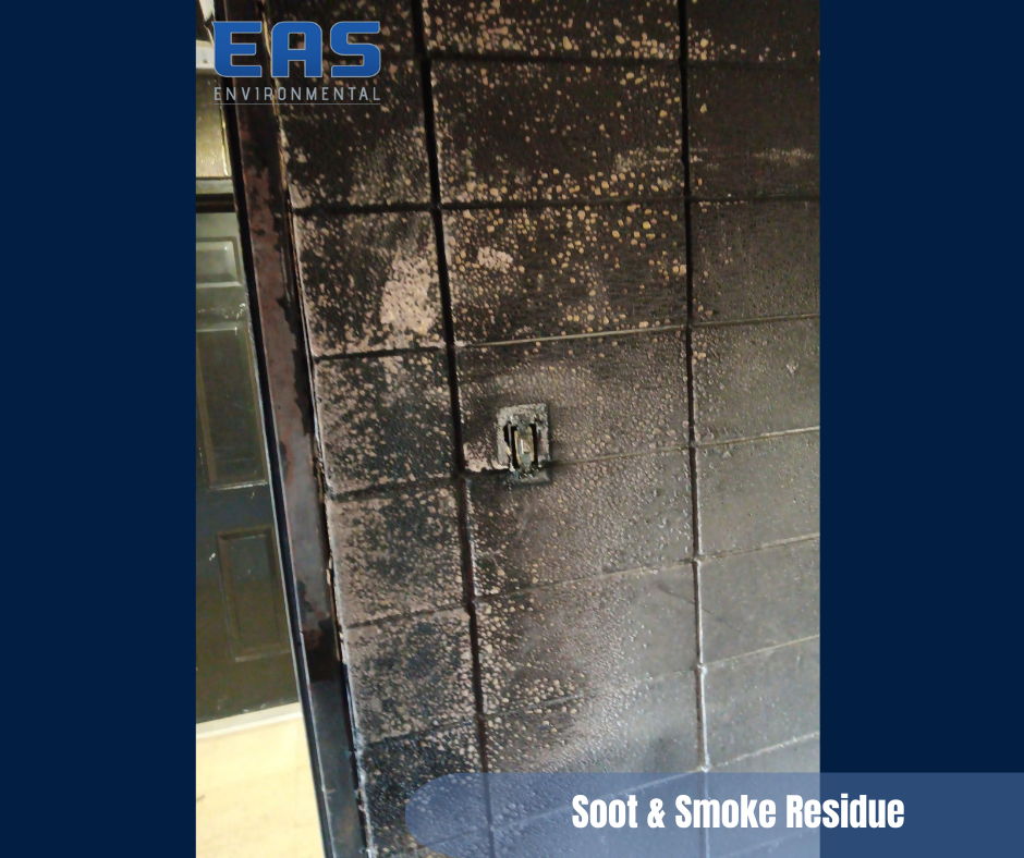 Workers painting a room with drop cloths. One on cart with pole, other on table in room with exposed ceiling.