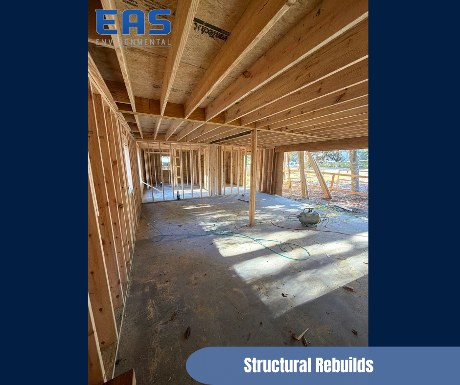 Workers in safety gear on a roof removing material with abatement equipment; urban setting with buildings in background.
