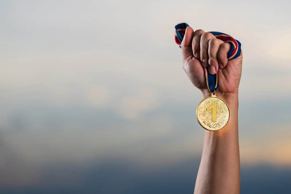 Hand Holding A Gold Sports Medal