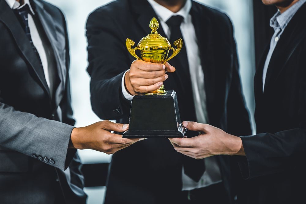 Group of Businessman Holding Gold Winner Cup — NQ Plaques & Trophies In Kirwan, QLD
