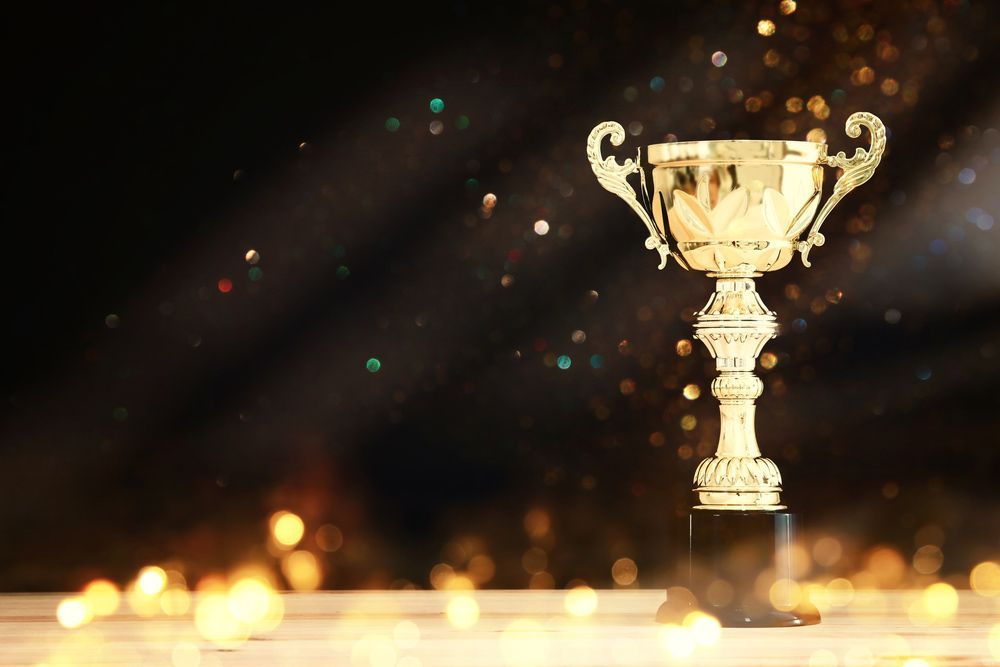 A Gold Trophy Is Sitting On Top Of A Wooden Table — NQ Plaques & Trophies In Rockhampton, QLD
