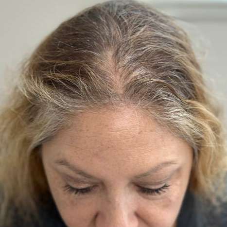 a close up of a woman 's head with gray hair .