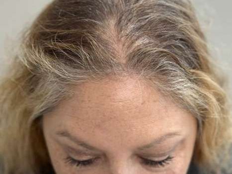a close up of a woman 's head with gray hair .