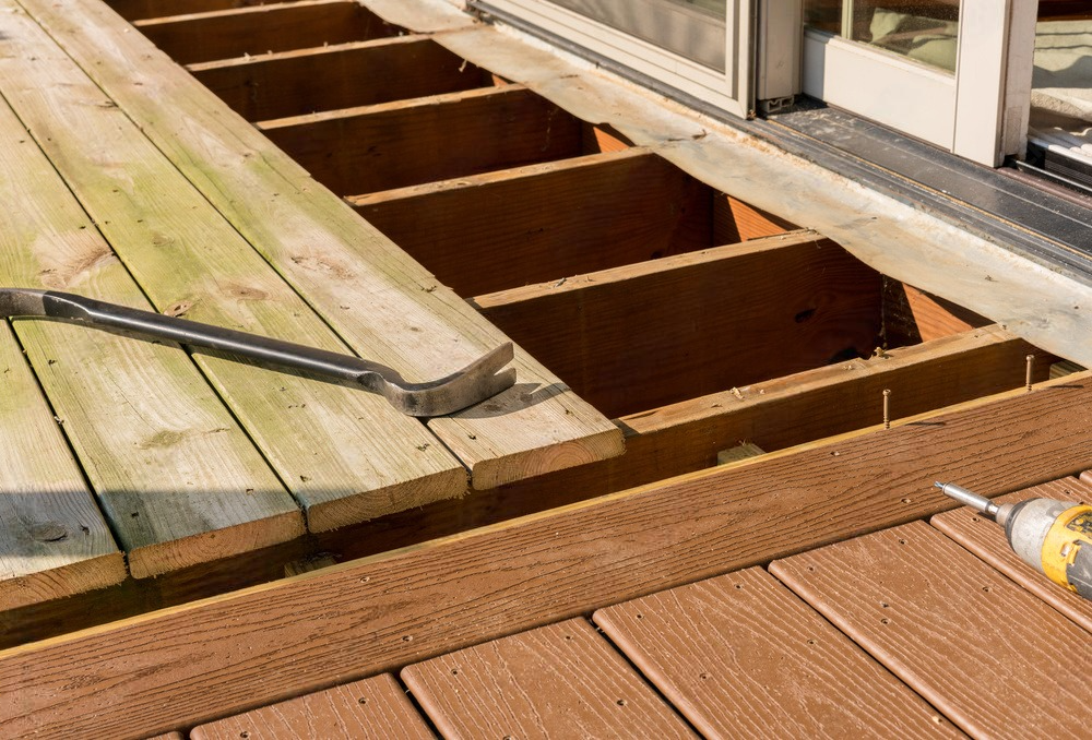 a wooden deck is being built with a hammer and a tape measure .