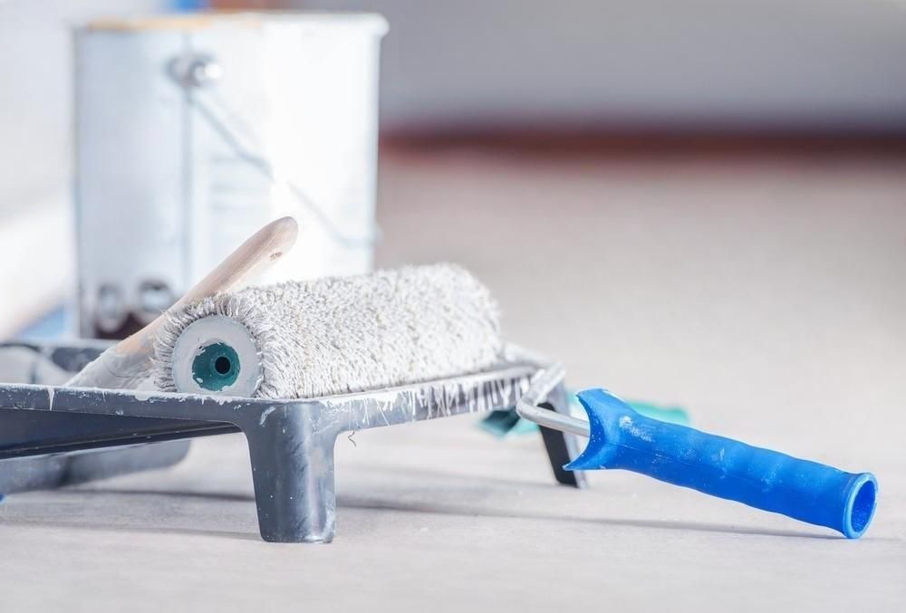 a paint roller is sitting on top of a paint tray .