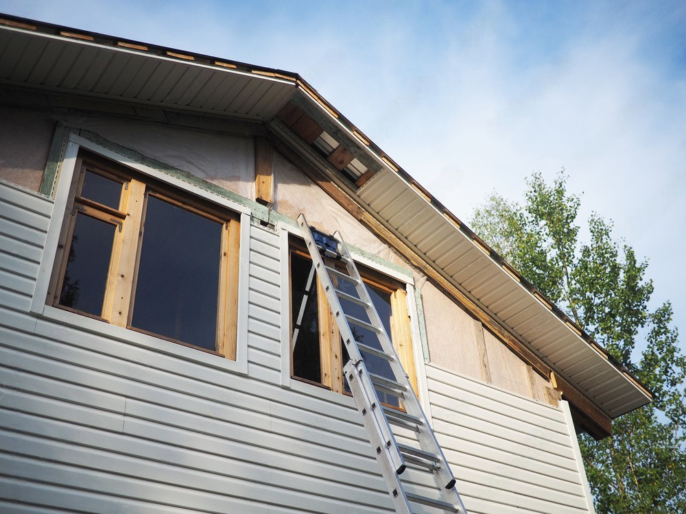 a ladder is attached to the side of a house under construction .