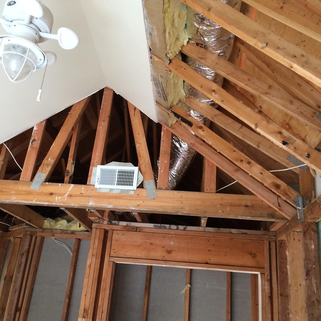 A ceiling fan is hanging from the ceiling of a house under construction