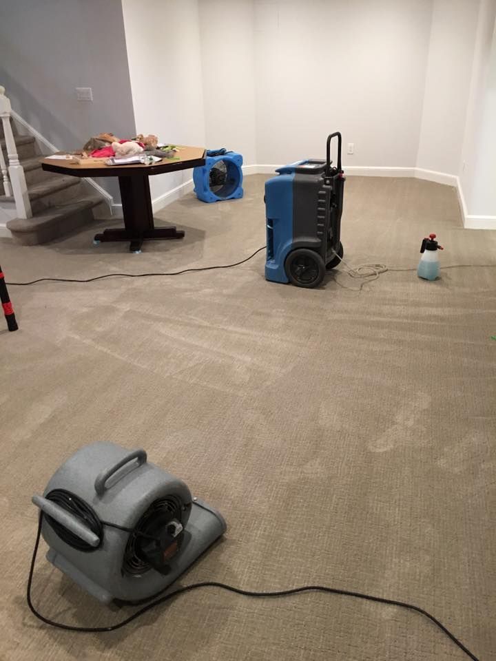 A room with a table and two fans on the floor.