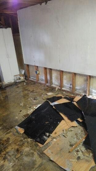 A flooded basement with a lot of pieces of cardboard on the floor.