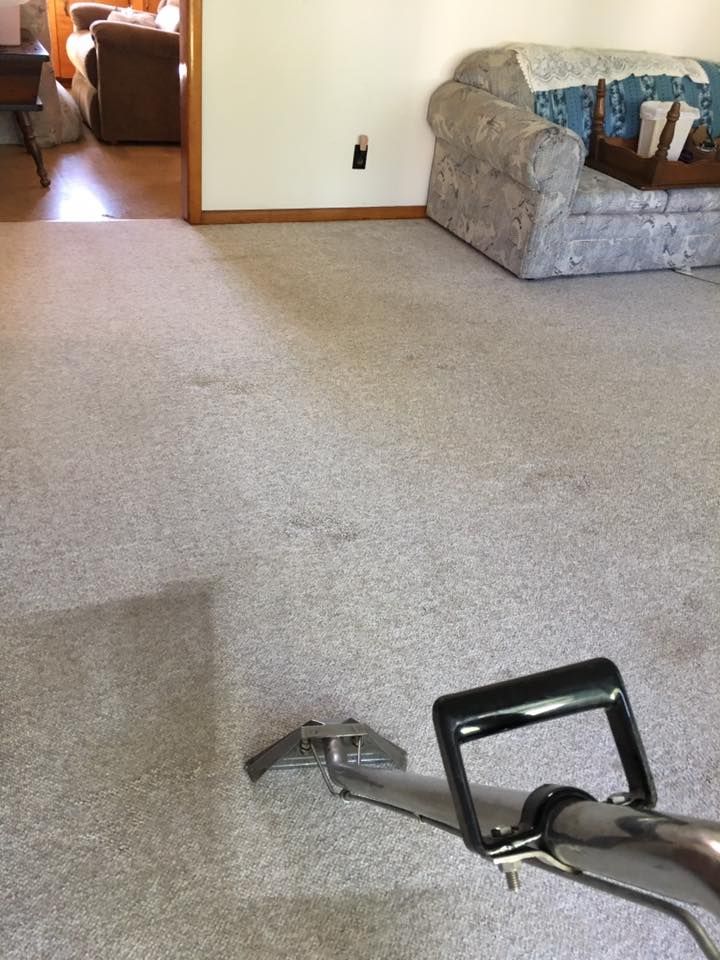 A vacuum cleaner is sitting on a carpet in a living room.