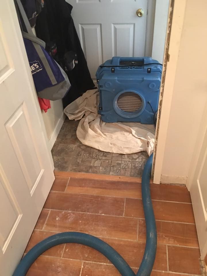 A vacuum hose is connected to a machine in a room.