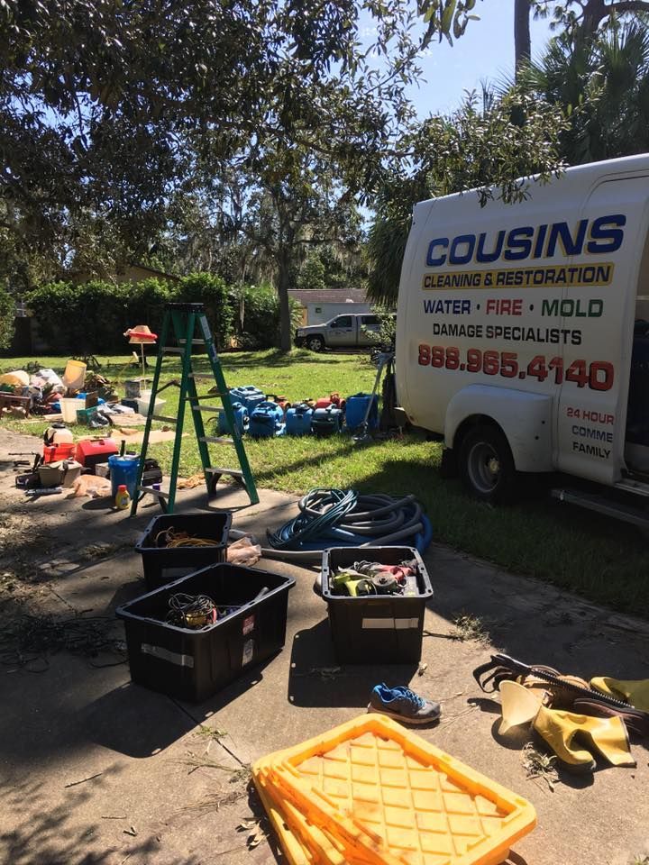 A white van with the word cousins on it is parked on the side of the road.