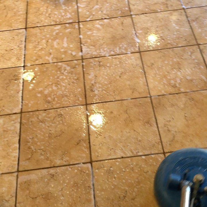 A tile floor is being cleaned with a machine