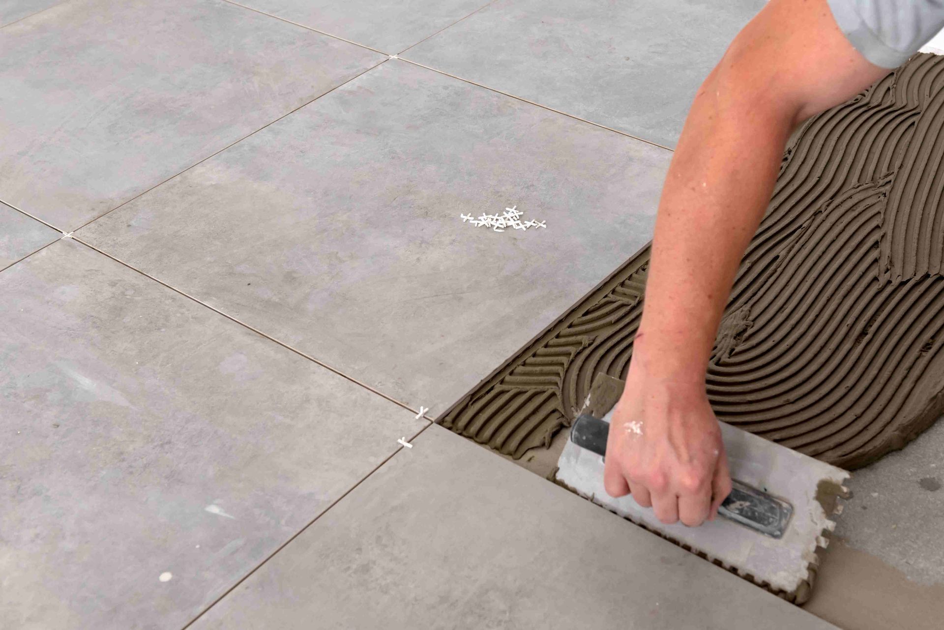 A man installing tile on a bathroom floor