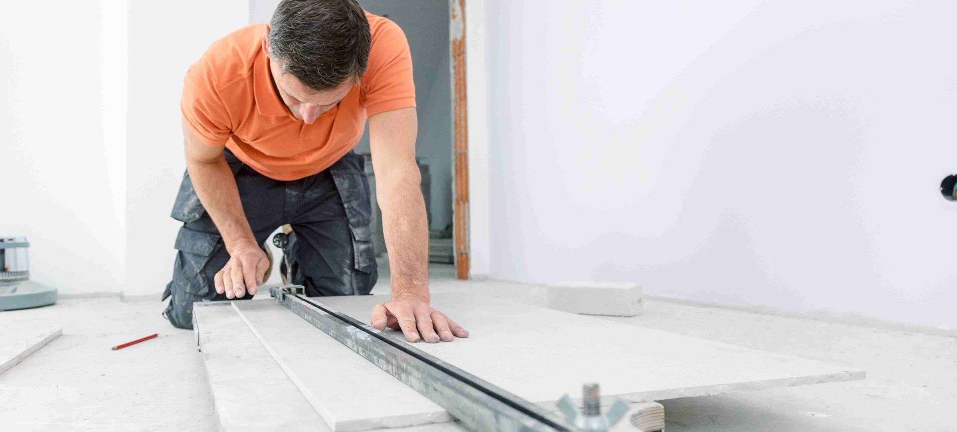 A man cutting tiles for a bathroom floor
