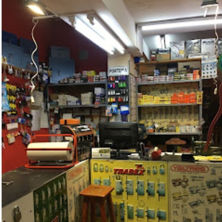 Interior de una ferretería que muestra estantes repletos de llaves, candados y suministros.