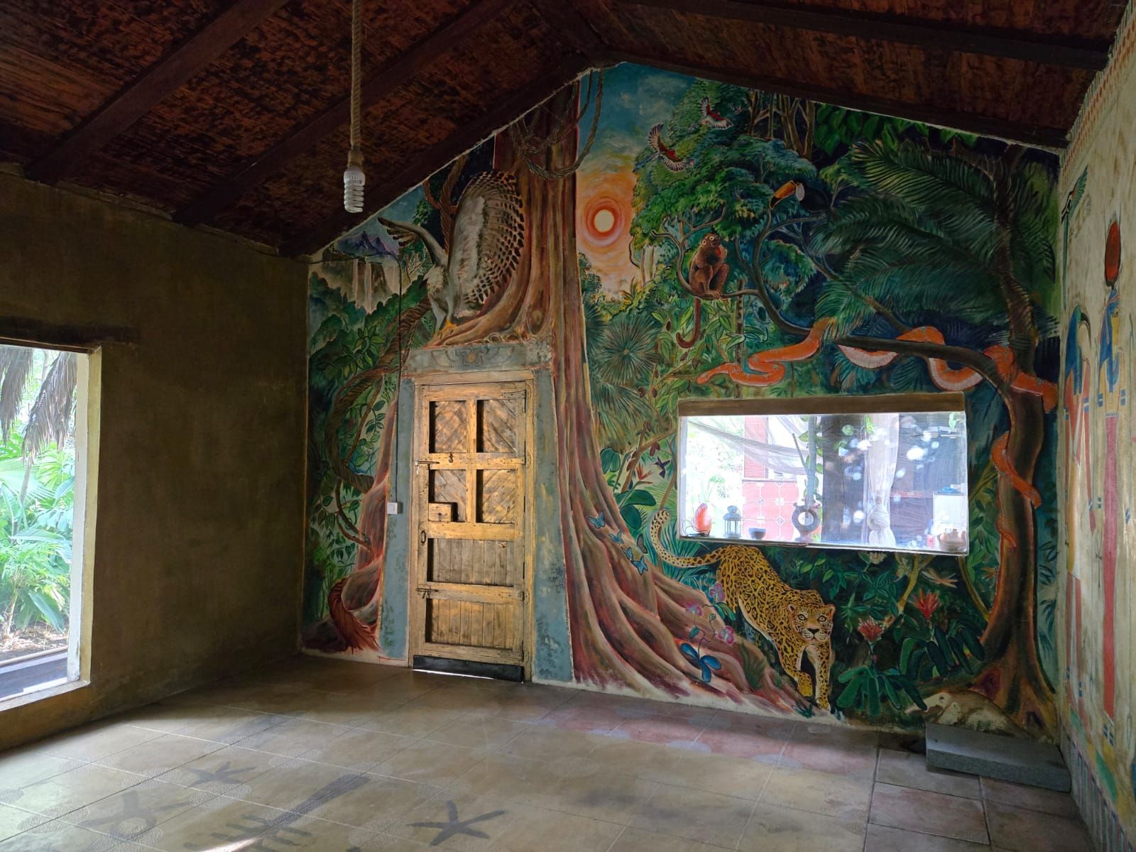 A room with a mural on the wall and a door.