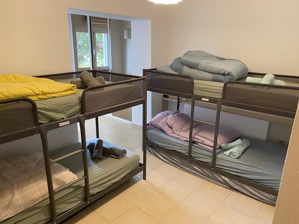 A room with four bunk beds and a window.