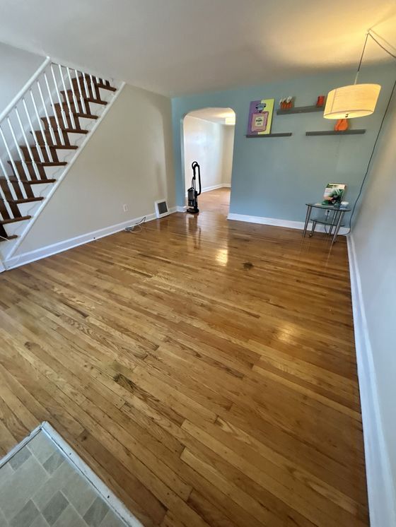 A living room with hardwood floors and stairs in a house.