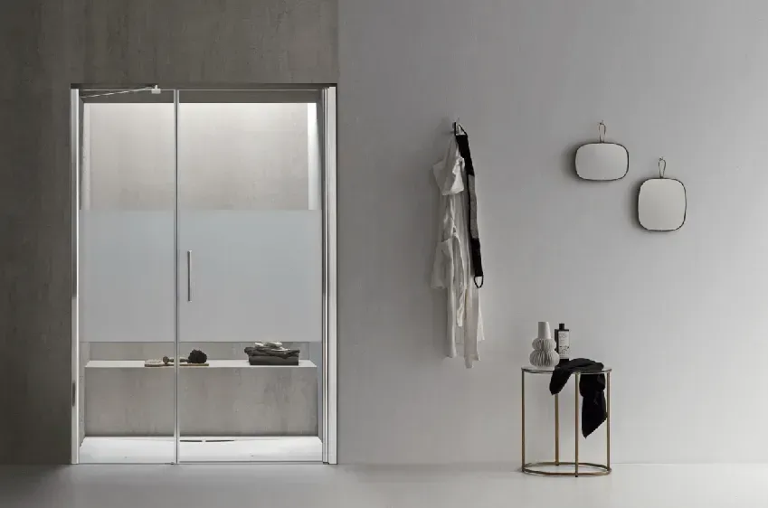 Bagno moderno con doccia in vetro, accappatoio, specchi e tavolino.
