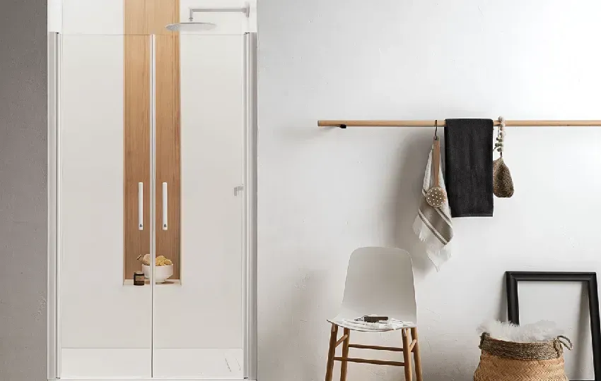 Mobile bianco con dettagli in legno, oggetti appesi a un'asta di legno, sedia e cestino intrecciato.