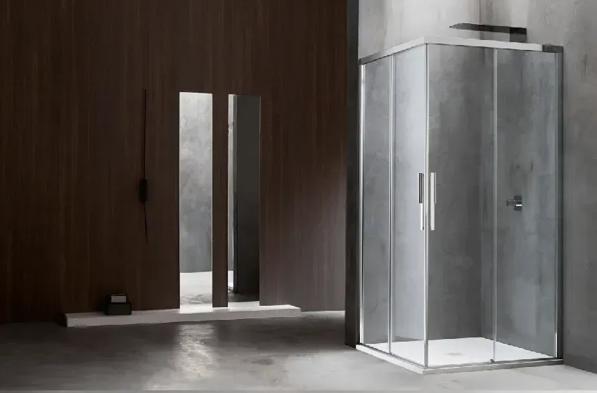 Box doccia moderno con porte in vetro, accanto a una parete in legno scuro e uno specchio.