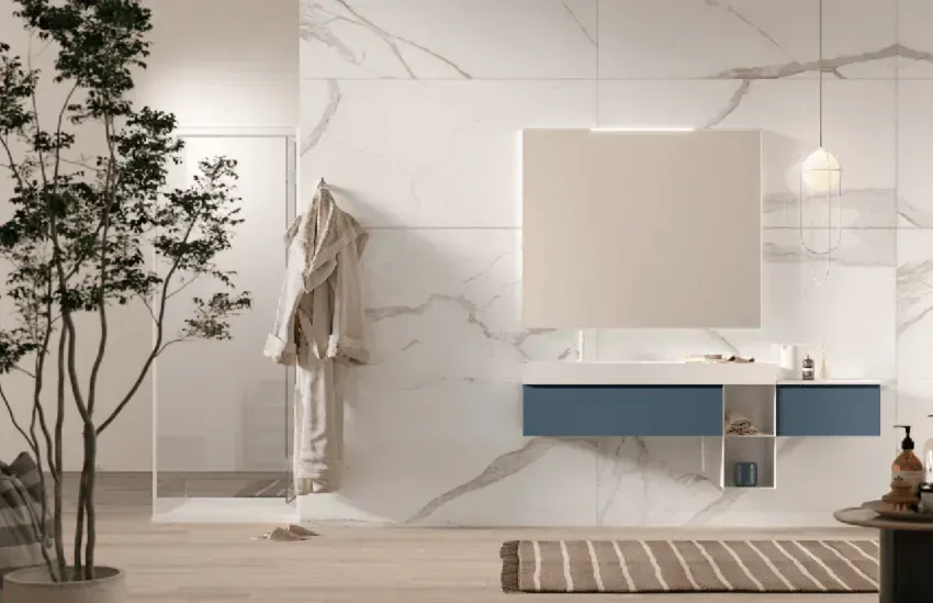 Bagno moderno con pareti effetto marmo, mobile lavabo blu, grande specchio e un albero.