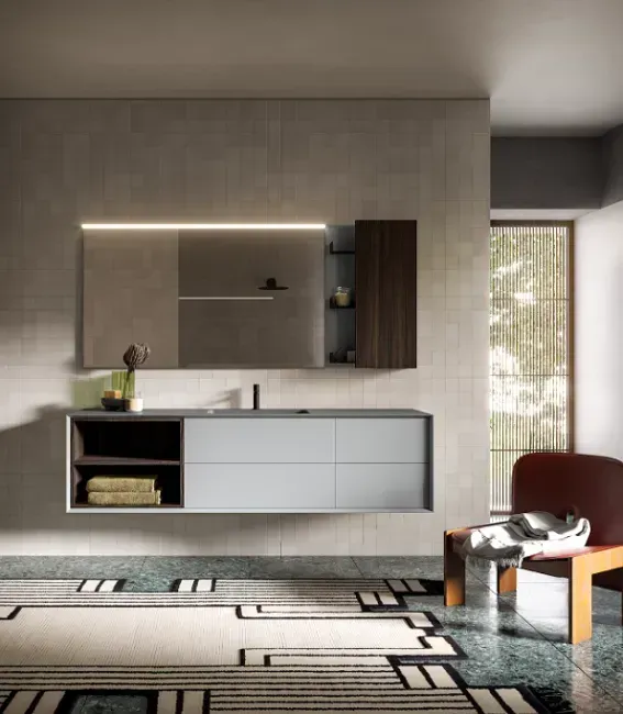 Bagno moderno con mobile lavabo sospeso, grande specchio e pavimento decorato.