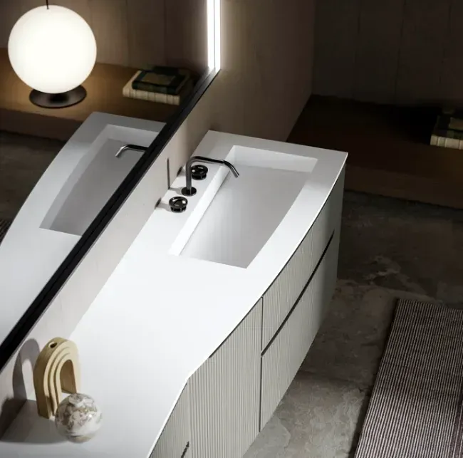 Mobile da bagno moderno con piano bianco e lavabo integrato, visto dall'alto.