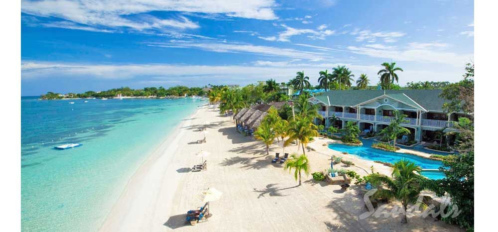 An aerial view of a tropical beach with a hotel in the background.