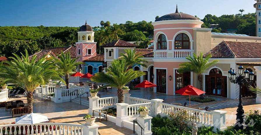 An aerial view of a resort with palm trees and umbrellas