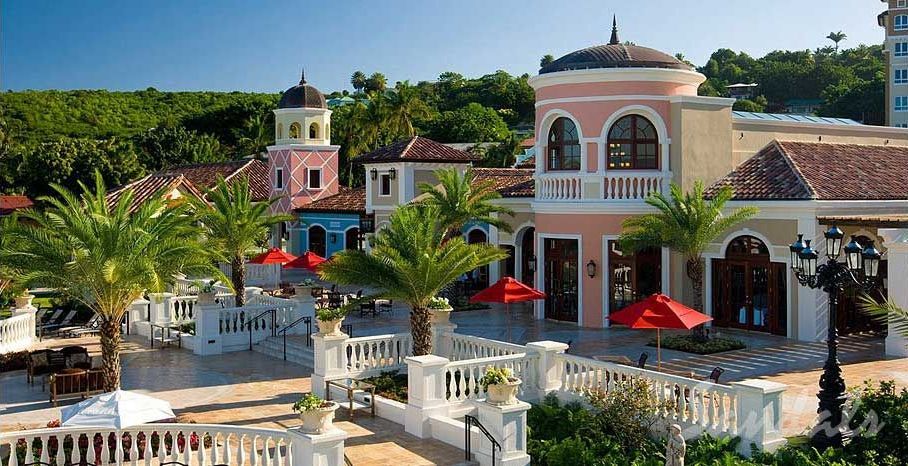An aerial view of a resort with palm trees and umbrellas