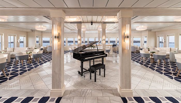 A grand piano is sitting in the middle of a large room.
