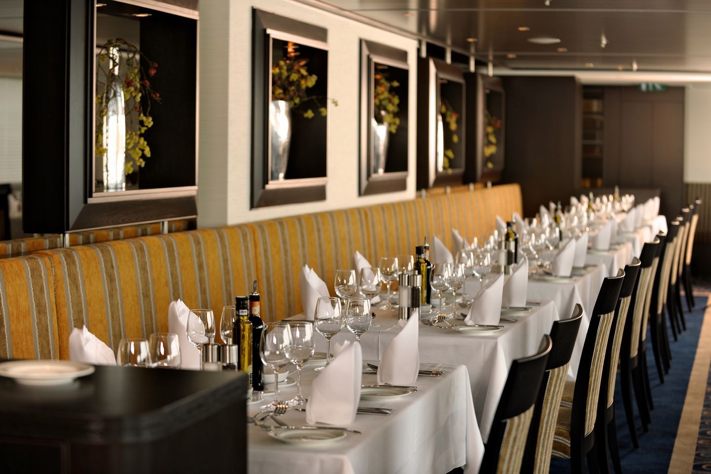 A long dining room with tables and chairs set for a meal