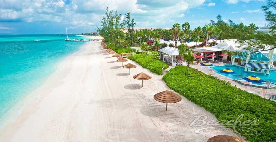 An aerial view of a beach with umbrellas and a pool.