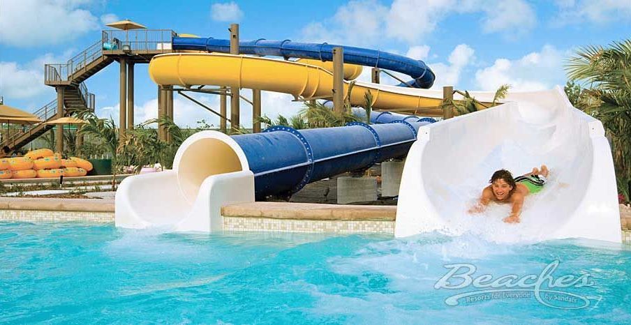 A child is sliding down a water slide at a water park.