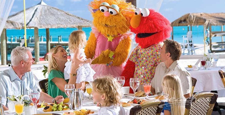 A family is sitting at a table with elmo and sesame street characters.