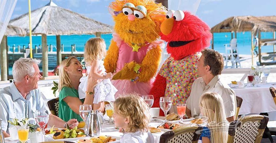 A family is sitting at a table with elmo and sesame street characters.