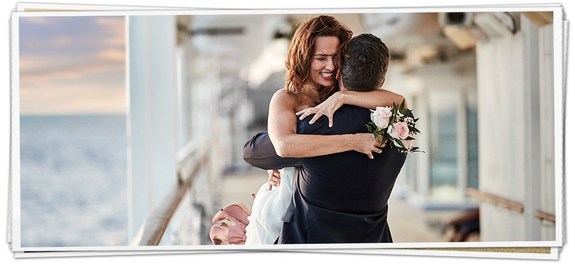 A bride and groom are hugging on a cruise ship.