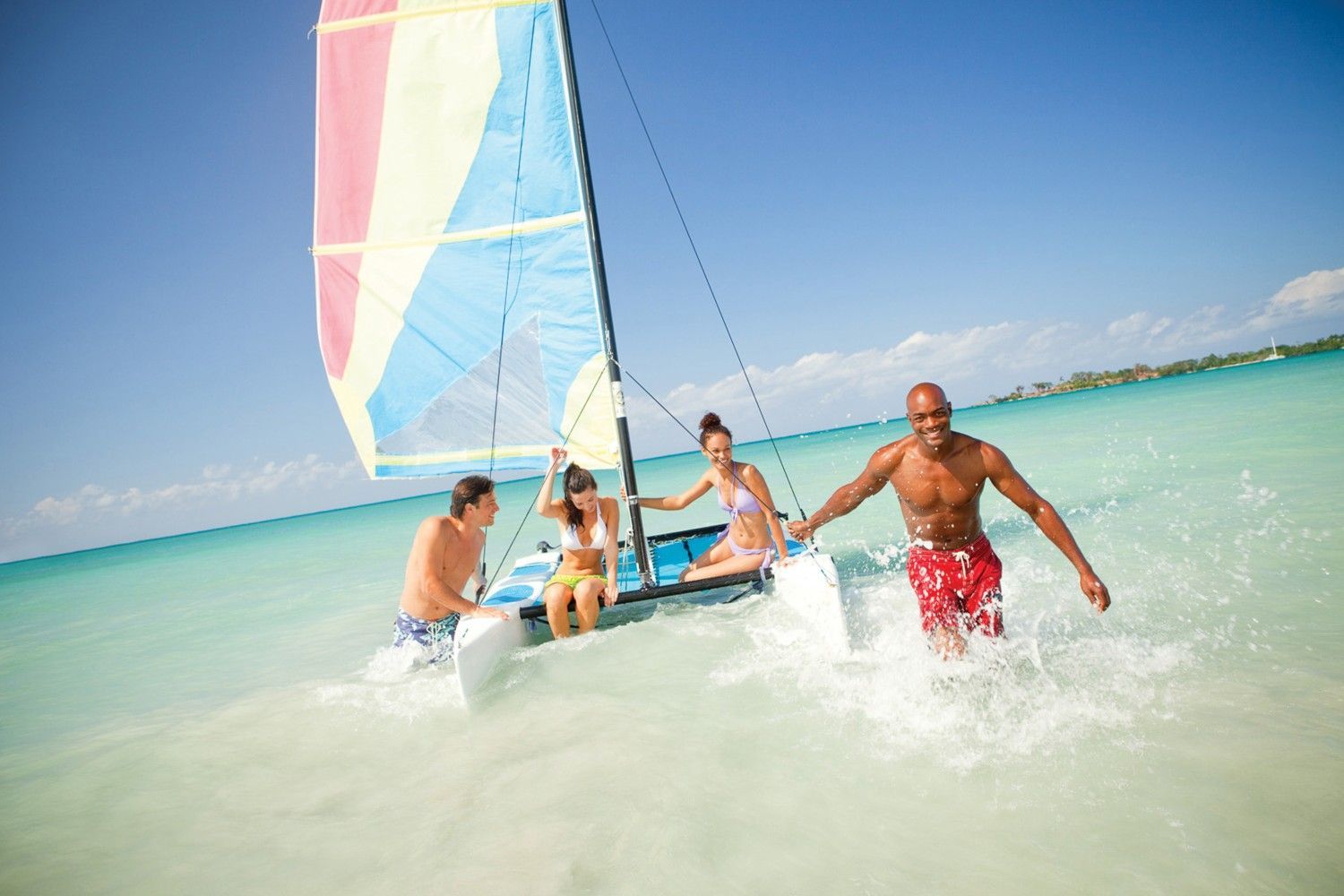A group of people are on a sailboat in the ocean.