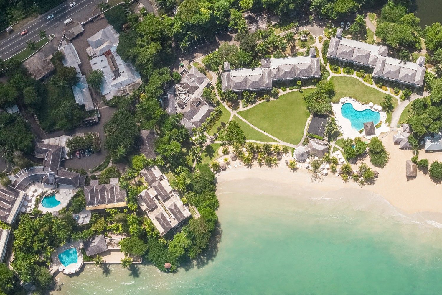 An aerial view of a beach resort with a lot of buildings and trees.