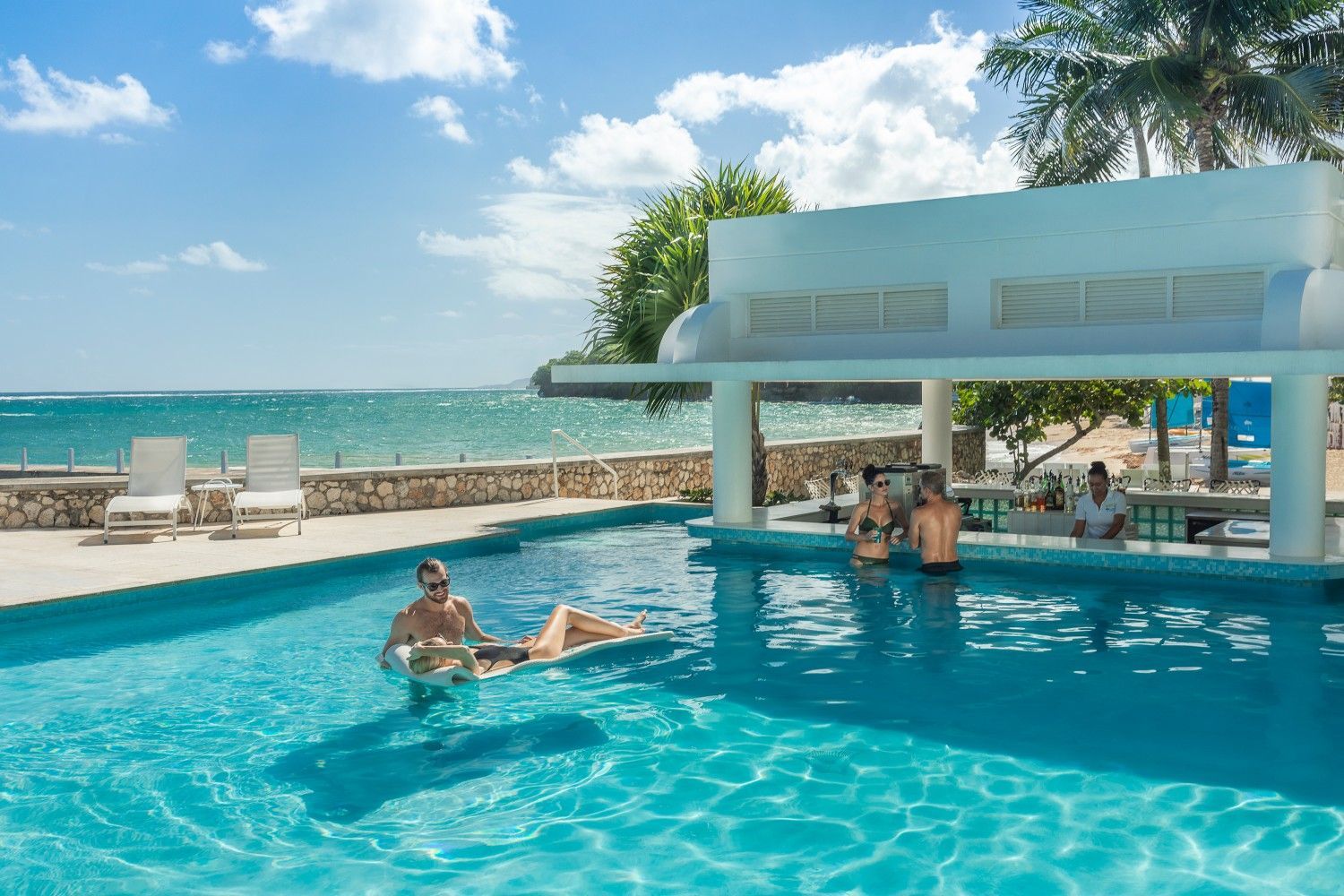 A group of people are sitting at a bar in a swimming pool.