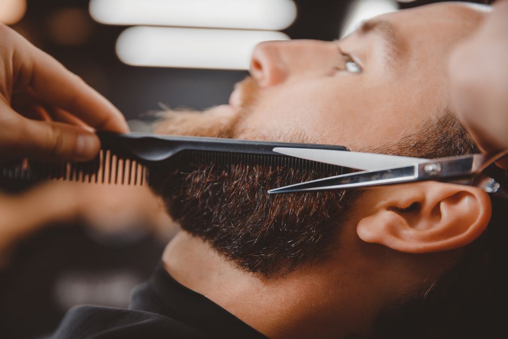 Barber Trimming a Bearded Man's Beard with Scissors and A Comb — Ultimate Barber in Maryborough, QLD