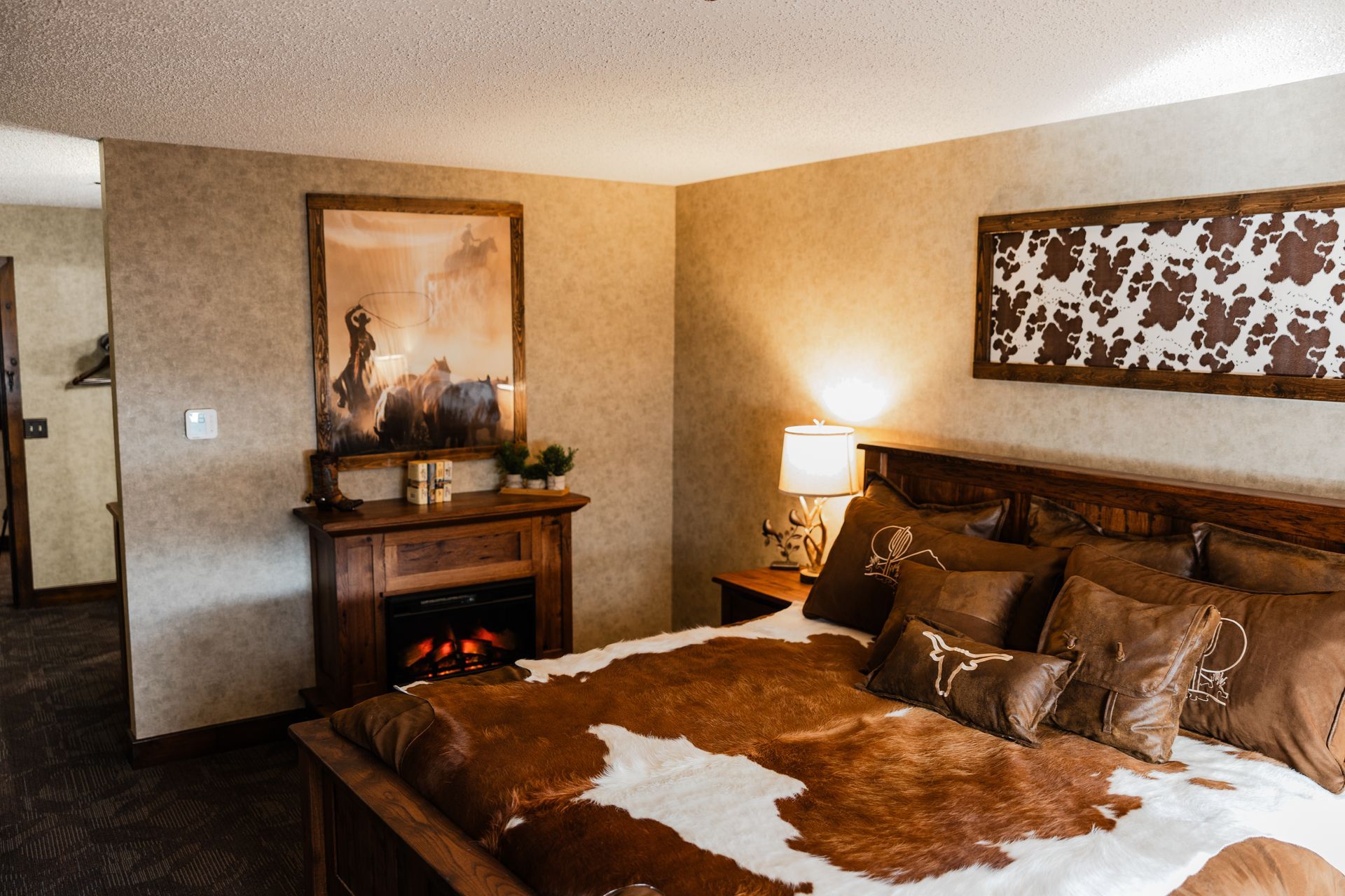 A bedroom with a king size bed and a fireplace.