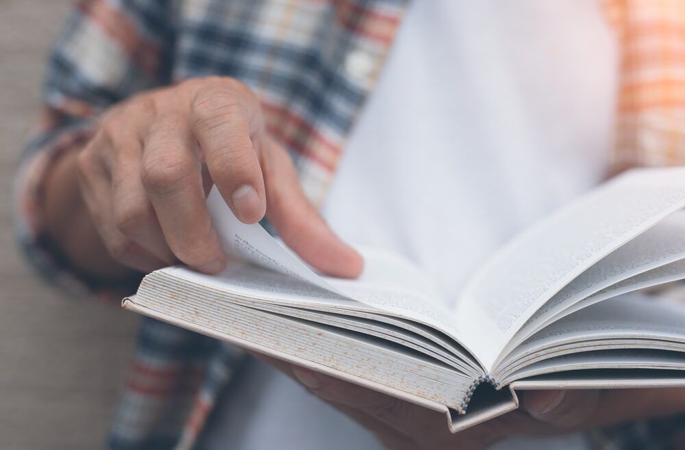 Un primer plano de una persona leyendo un libro.