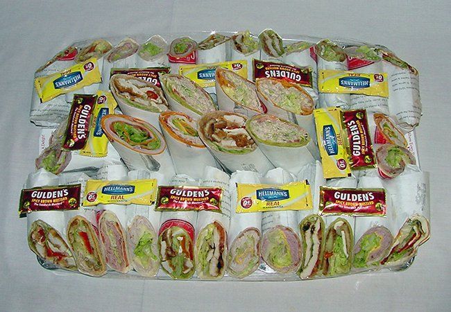 A tray of sandwiches and wraps on a table