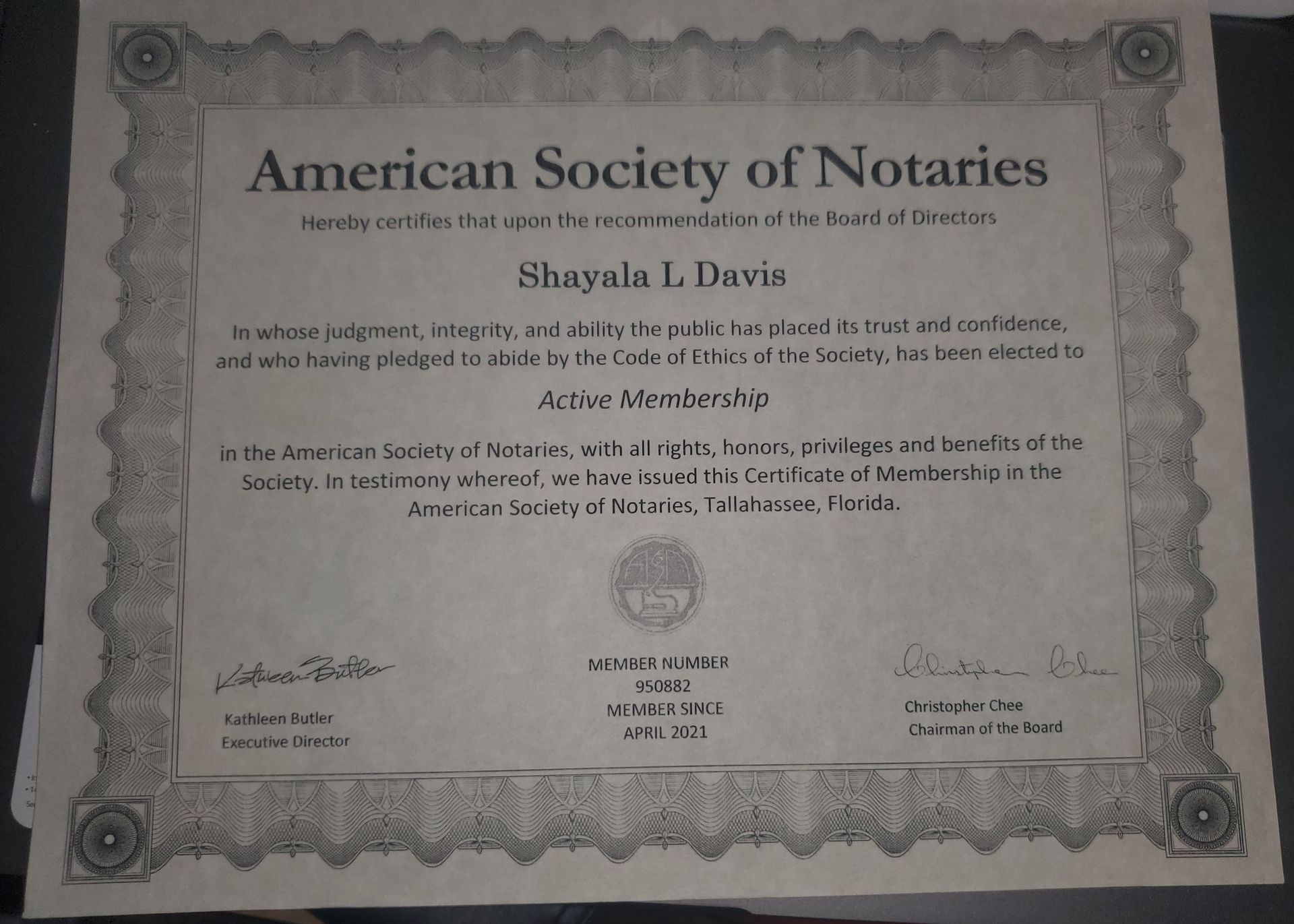 A certificate from the american society of notaries sits on a table