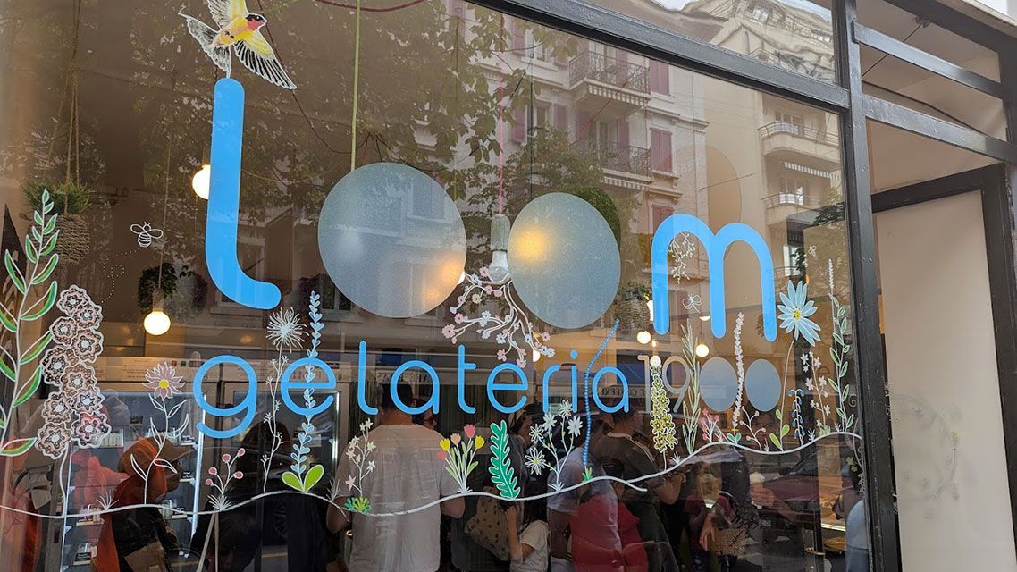 Panneau bleu « Loom Gelato » sur la fenêtre, personnes visibles à l'intérieur.