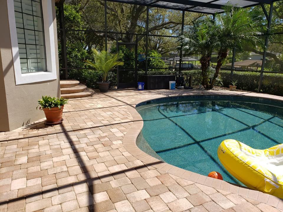 There is a fire pit on the patio with chairs around it.